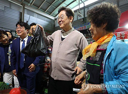 지역화폐로 식재료 구매하는 이재명 후보(영천=연합뉴스) 김도훈 기자 = 더불어민주당 이재명 대선 후보가 제3차 골목골목 경청투어로 경북지역 방문에 나선 9일 경북 영천시 영천공설시장을 찾아 한 가게에서 영천사랑상품권으로 말린 고추를 구매하고 있다. 2025.5.9 superdoo82@yna.co.kr