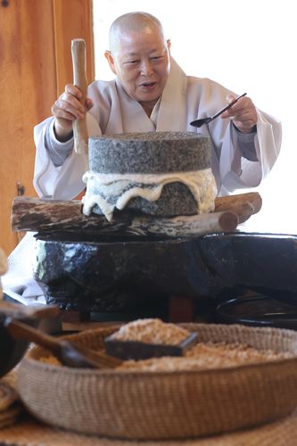 맷돌 돌리는 계호스님(서울=연합뉴스) 강민지 기자 = 진관사 회주 계호스님이 4월 23일 서울 은평구 진관사에서 맷돌로 콩을 갈고 있다. 2025.5.11     mjkang@yna.co.kr