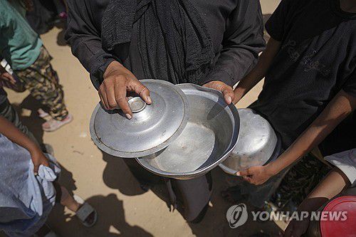 식량 바닥 난 가자지구(가자지구 칸유니스 AP=연합뉴스) 2025년 5월 9일 가자지구 남부 칸유니스의 한 급식소에서 식재료가 바닥나자 한 여성이 비어 있는 그릇을 열어 보고 있다. (AP Photo/Abdel Kareem Hana) 2025.5.10.