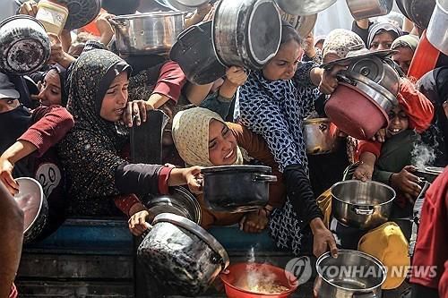 밥을 배급받기 위해 몰려든 가자 주민들[UPI=연합뉴스 자료사진. 재판매 및 DB금지]