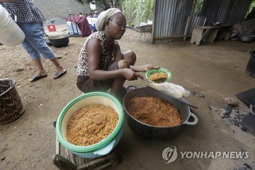 아프리카 서부 라이베리아에서 쌀 요리 '졸로프 라이스'를 준비하는 여성[EPA 연합뉴스 자료사진. 재판매 및 DB 금지]