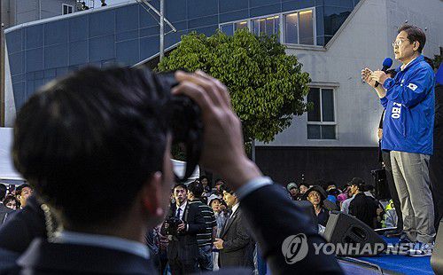 이재명 후보는 연설, 경찰은 테러 대비 경호(목포=연합뉴스) 황광모 기자 = 더불어민주당 이재명 대선후보가 15일 전남 목포시 평화광장 원형상가 앞에서 열린 유세에서 지지를 호소하는 연설을 하고 있다.      유세차 아래에서 경찰 경호 관계자가 테러 위협에 대응하기 위해 특수 쌍안경을 이용해 근처 건물을 계속 지켜보고 있다. 2025.5.15 hkmpooh@yna.co.kr