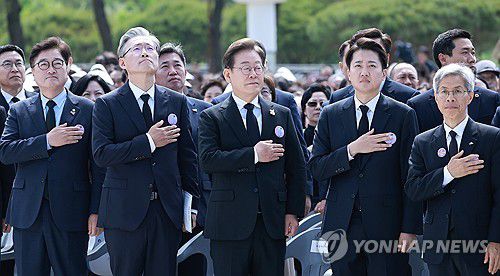5.18기념식 참석한 대선후보들(광주=연합뉴스) 홍해인 기자 = 더불어민주당 이재명, 개혁신당 이준석, 민주노동당 권영국 대선 후보 등이  18일 광주광역시 북구 국립 5·18민주묘지에서 열린 5·18민주화운동 45주년 기념식에서 국기에 경례하고 있다. 2025.5.18 hihong@yna.co.kr