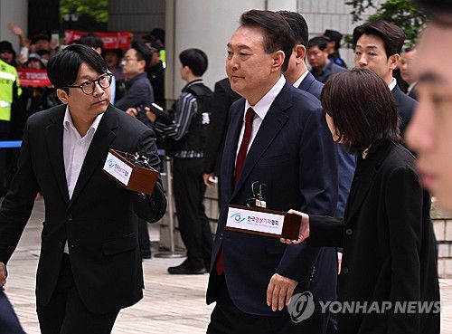 법정 향하는 윤석열 전 대통령(서울=연합뉴스) 윤석열 전 대통령이 19일 서울 서초구 중앙지방법원에서 열린 내란 우두머리 혐의, 직권남용 권리행사방해 혐의 사건 4차 공판에 출석, 취재진의 질문을 받으며 이동하고 있다. 2025.5.19 [사진공동취재단] photo@yna.co.kr