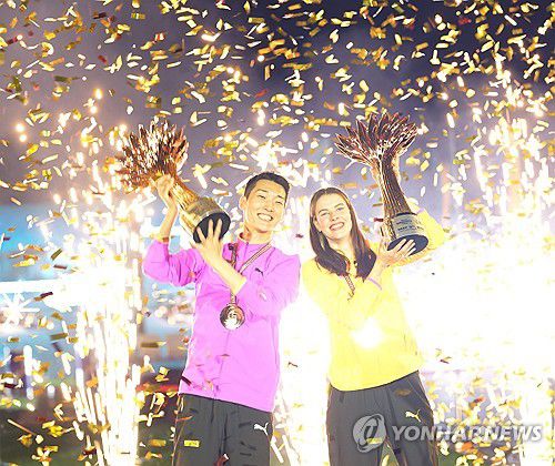 왓 그래비티 챌린지 트로피 든 우상혁(서울=연합뉴스) 우상혁이 10일(한국시간) 카타르 도하 카타라 원형극장에서 열린 왓 그래비티 챌린지 남자 높이뛰기 대회에서 우승한 뒤, 여자부 1위 마후치크와 기념 촬영하고 있다. 2025.5.10 [용인시청 육상팀 제공. 재판매 및 DB 금지] photo@yna.co.kr