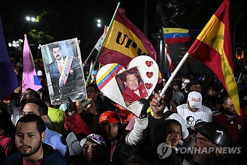 차베스와 마두로 사진 손팻말 들고 나온 베네수엘라 여당 지지자[카라카스 AFP=연합뉴스. 재판매 및 DB 금지]