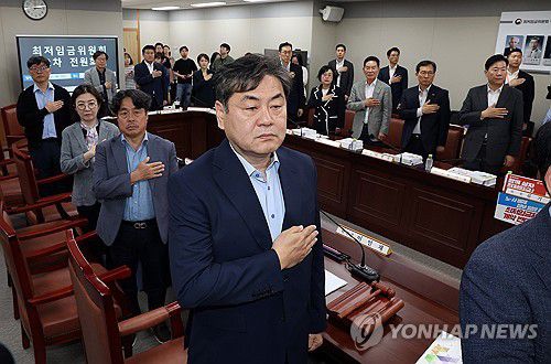 국기에 경례하는 최저임금 위원들(세종=연합뉴스) 배재만 기자 = 이인재 최저임금위원장을 비롯한 위원들이 27일 정부세종청사에서 열린 최저임금위원회 제2차 전원회의에서 국기에 경례하고 있다. 2025.5.27 scoop@yna.co.kr