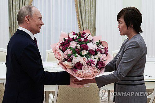 아베 부인에게 꽃다발 선물하는 푸틴 대통령[타스/러시아 대통령실 연합뉴스. 재판매 및 DB 금지]