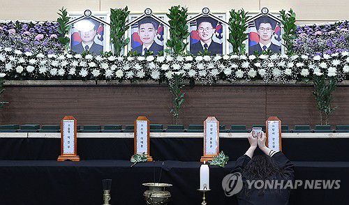 순직 해군 영정 앞 결혼반지와 명찰(포항=연합뉴스) 윤관식 기자 = 30일 경북 포항시 남구 해군 항공사령부 체육관에 마련된 '해군 P-3CK 917호기 순직자 합동분향소'에서 순직 해군 유족이 결혼반지를 들고 오열하고 있다. 2025.5.30 psik@yna.co.kr