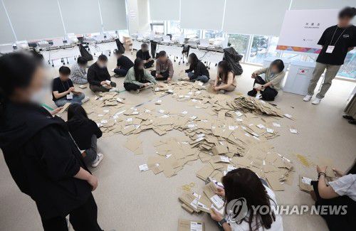 대선 사전투표 끝(서울=연합뉴스) 김도훈 기자 = 제21대 대통령선거 사전투표 둘째 날인 30일 서울 중구 을지누리센터에 마련된 사전투표소에서 사전투표사무원들이 참관인 및 공정선거참관단이 지켜보는 가운데 관외투표함을 열어 투표용지 분류 작업을 하고 있다. 2025.5.30 superdoo82@yna.co.kr