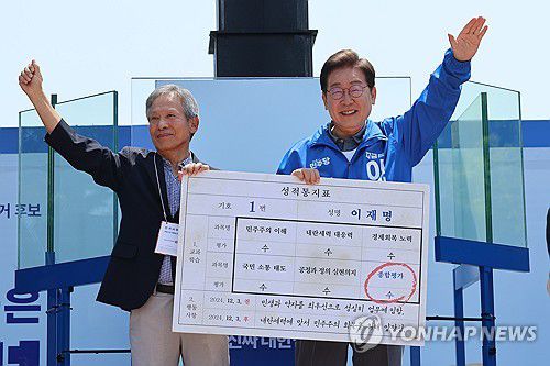 은사님께 '대선 후보 성적표' 받는 이재명 후보(안동=연합뉴스) 김주성 기자 = 더불어민주당 이재명 대선 후보가 선거를 이틀 앞두고 '험지 공략'에 나선 1일 고향인 경북 안동시의 웅부공원에서 열린 유세에서 이 후보의 초등학교 은사인 박병기 선생님으로부터 대선 후보 모의 성적 통지표를 받고 있다. 2025.6.1 utzza@yna.co.kr