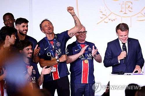 마크롱 대통령의 축하 인사에 손을 들어 화답하는 엔리케 감독[AFP=연합뉴스]