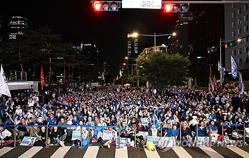 개표방송 지켜보는 지지자들(서울=연합뉴스) 김주성 기자 = 4일 서울 여의도 국회 인근에서 더불어민주당 주최로 열린 제21대 대통령 선거 국민개표방송 행사에 참석한 시민들이 방송예측시스템에서 이재명 대선 후보의 '당선 확실'이 나오자 환호하고 있다. 2025.6.4 [공동취재] utzza@yna.co.kr