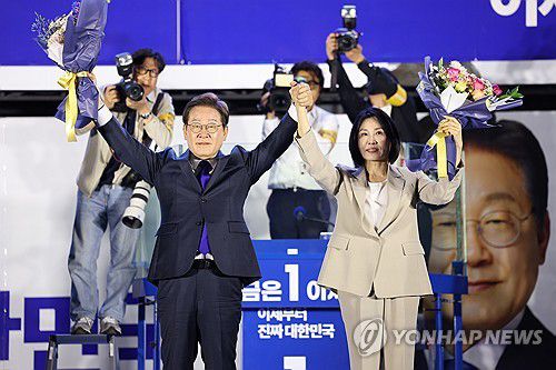 인사하는 이재명 후보와 김혜경 여사(서울=연합뉴스) 김주성 기자 = 제21대 대통령 당선이 확실시되는 더불어민주당 이재명 대선 후보와 부인 김혜경 여사가 4일 서울 여의도 국회 인근에서 당 주최로 열린 국민개표방송 행사에 참석해 꽃다발을 받고서 시민들을 향해 두 팔을 들어 인사하고 있다. 2025.6.4 [공동취재] utzza@yna.co.kr