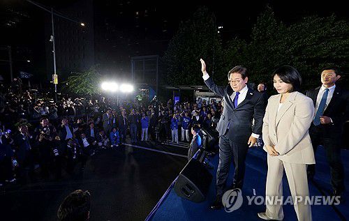 인사하는 이재명 후보와 김혜경 여사(서울=연합뉴스) 김주성 기자 = 제21대 대통령 당선이 확실시되는 더불어민주당 이재명 대선 후보와 부인 김혜경 여사가 4일 서울 여의도 국회 인근에서 당 주최로 열린 국민개표방송 행사에 참석해 시민들을 향해 손들어 인사하고 있다. 2025.6.4 [공동취재] utzza@yna.co.kr