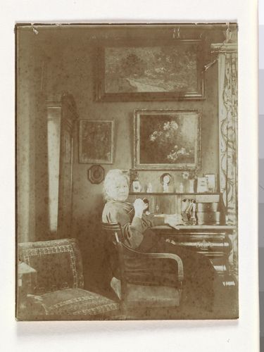 거실 책상 앞의 요 반 고흐 봉어르, 뒤편 벽에 빈센트 반 고흐의 '은선초 꽃병'(1884), '황혼 풍경'(1890) 등이 보인다. [(주)아트북스 제공. 재판매 및 DB 금지]