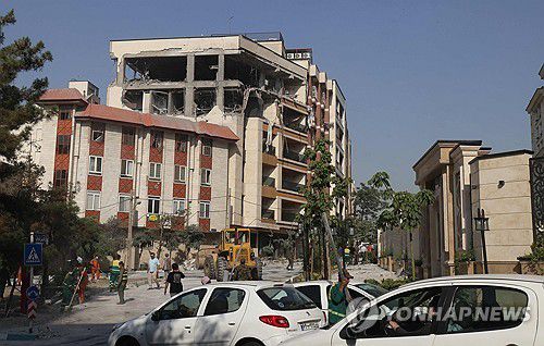 이스라엘 공습으로 파괴된 테헤란의 건물(테헤란 AFP=연합뉴스) 2025년 6월 13일 이스라엘군 공습으로 파괴된 이란 테헤란 시내 건물 앞에 사람들이 모여 있다. (Photo by ATTA KENARE / AFP) 2025.6.13.