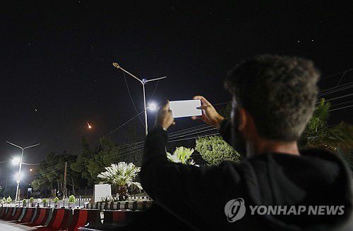 밤하늘의 이란 미사일을 촬영하는 시리아인(다마스쿠스 AP=연합뉴스) 16일 밤 시리아에서 한 남성이 다마스쿠스 상공을 지나 이란 미사일을 촬영하고 있다.