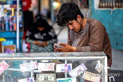 아프간 수도 카불서 휴대전화를 보는 환전상[AFP 연합뉴스 자료사진. 재판매 및 DB 금지]