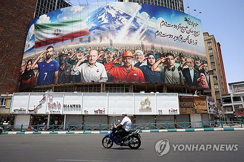 22일(현지시간) "우리는 모두 이란의 군인이다"라 쓰인 광고판을 지나는 테헤란 시민[EPA 연합뉴스]