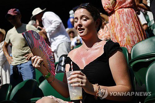 윔블던 경기 관람 중 더위를 식히는 관객[EPA=연합뉴스 자료사진. 재판매 및 DB 금지]