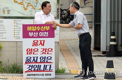 세종시장, 1인 시위 중 해수부 노조 사무총장 만나(세종=연합뉴스) 양영석 기자 = 최민호 세종시장이 2일 오전 정부세정청사에 입주한 해양수산부 정문 앞에서 '해수부 부산 이전은 옳지 않다'는 피켓을 들고 1인 시위를 하고 있다. 최 시장이 출근길에 만난 해수부 노조사무총장과 악수하고 있다. 2025.7.2 youngs@yna.co.kr