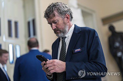 부채시계 전광판 모양 핀을 단 토머스 매시 의원(워싱턴DC AP=연합뉴스) 2일(현지시간) 토머스 매시 하원의원(공화·켄터키)이 미국 정부의 과도한 재정적자를 지적하는 '부채시계'(debt clock) 전광판 모양 핀을 상의 옷깃에 부착한 채 워싱턴DC 미 의회의사당 내부를 이동하는 모습. 2025.6.2