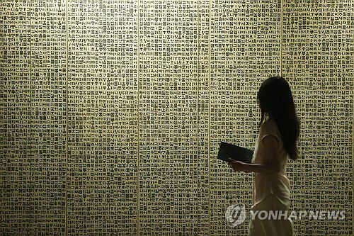 1만 자를 병풍에 담은 '월인천강지곡'(서울=연합뉴스) 강민지 기자 = 10일 서울 서초구 예술의전당 서울서예박물관에서 열린 '평보 서희환: 보통의 걸음' 전시 프리뷰에서 관계자가 '월인천강지곡'을 살펴보고 있다. 2025.7.10 mjkang@yna.co.kr