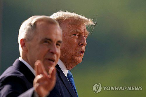 카니 캐나다 총리와 트럼프 미국 대통령(캐내내스키스<캐나다 앨버타주> AFP=연합뉴스 자료사진) 2025년 6월 16일 캐나다 앨버타주 캐내내스키스에서 열린 G7 정상회의 가족사진 촬영 행사에 참석하기 위해 이동중인 마크 카니(왼쪽) 캐나다 총리와 도널드 트럼프(오른쪽) 미국 대통령. (Photo by Geoff Robins / AFP) 2025.7.11.