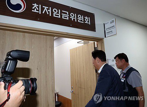 입장하는 류기정-류기섭(세종=연합뉴스) 배재만 기자 = 최저임금위원회 사용자위원인 류기정 한국경영자총협회 전무(왼쪽)와 근로자위원 류기섭 한국노총 사무총장이 10일 정부세종청사에서 열린 최저임금위원회 제12차 전원회의에서 민주노총 위원들이 심의를 거부한 채 퇴장해 회의가 정회된 후 밖에서 얘기를 나누고 들어오고 있다. 2025.7.10 scoop@yna.co.kr