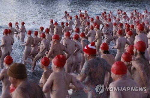 호주 겨울바다 수영축제에 참여한 시민들호주 태즈메이니아주 호바트 샌디 베이의 롱비치에서 열린 '다크 모토 페스티벌'(Dark Mofo Festival)에서 수영모만 쓴 시민들이 바다로 뛰어들고 있다. [EPA 연합뉴스 자료사진. 재판매 및 DB 금지]