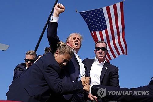 작년 피격직후 현장 떠나며 주먹 치켜든 트럼프[AP 연합뉴스 자료사진 재판매 및 DB금지]