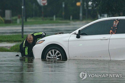 13일(현지시간) 미 텍사스 지역의 폭우로 도로 위 침수된 자동차[AFP=연합뉴스. 재판매 및 DB 금지]
