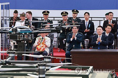 드론 바라보는 윤석열 대통령(서울=연합뉴스) 홍해인 기자 = 윤석열 대통령이 1일 서울 광화문 일대에서 열린 국군의날 시가행진 중 세종대왕상 앞 관람 무대 앞을 지나는 드론을 바라보고 있다. 2024.10.1 hihong@yna.co.kr