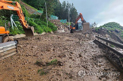 도로에 쏟아진 흙과 돌(울릉=연합뉴스) 14일 경북 울릉군 북면 현포리 도로에 흙과 돌이 쏟아져 울릉군이 장비와 인력을 동원해 치우고 있다. 2025.7.14 [울릉군 제공. 재판매 및 DB 금지] sds123@yna.co.kr