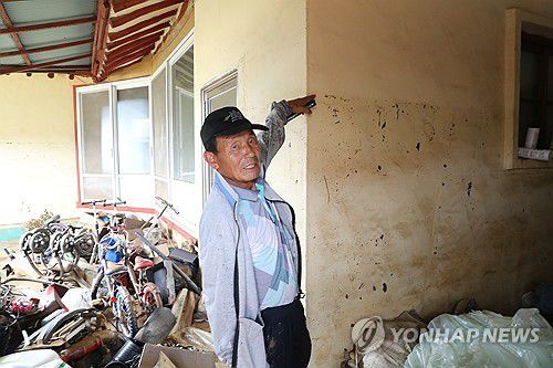 "성인 키보다 높다"(예산=연합뉴스) 한종구 기자 = 18일 오전 충남 예산군 삽교읍 하포리 폭우 피해 현장에서 한 주민이 성인 키만큼 물이 차올랐음을 설명하고 있다. 2025.7.18. jkhan@yna.co.kr