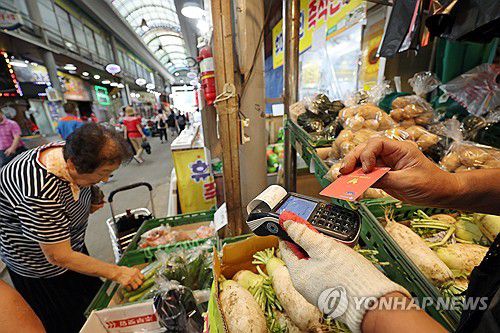 민생소비쿠폰에 활기 찾은 말바우시장(광주=연합뉴스) 김혜인 기자 = 22일 광주 북구 말바우시장에서 한 상인이 손님으로부터 받은 민생소비쿠폰으로 결제하고 있다. 말바우시장은 지난 17일 400㎜가 넘는 폭우가 내려 침수 피해를 입었다가 복구 작업을 거쳐 장이 열렸다. 2025.7.22 in@yna.co.kr