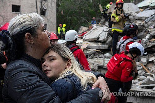 폭격으로 폐허 된 집 바라보는 키이우 주민들(키이우 AFP=연합뉴스) 2025년 7월 31일 폭격으로 파괴된 우크라이나 수도 키이우의 한 주거용 건물 앞에서 주민들이 서로를 껴안고 있다. (Photo by OLEKSII FILIPPOV / AFP) 2025.8.1.