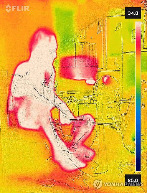 속절없는 쪽방촌의 폭염(서울=연합뉴스) 서대연 기자 = 서울 한낮 기온이 34도까지 치솟으며 무더운 날씨를 보인 24일 서울역 쪽방촌에서 한 주민이 에어컨이 없는 방에서 더위를 견디고 있다.      열화상 카메라 촬영. 온도가 높은 곳은 붉게, 낮은 곳은 푸르게 표시돼 있다. 2025.7.24 dwise@yna.co.kr