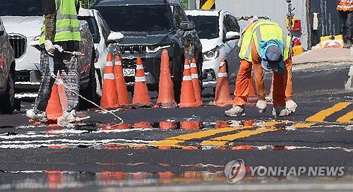 더위와 가장 가까운(대구=연합뉴스) 윤관식 기자 = 폭염이 이어진 31일 대구 수성구 수성못오거리에서 노동자들이 달궈진 도로에서 차선 도색 작업을 하고 있다. 2025.7.31 psik@yna.co.kr