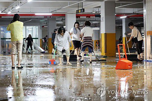 흙탕물 범벅 된 무안군보건소(무안=연합뉴스) 정다움 기자 = 호우 특보가 발효돼 시간당 142.1㎜의 집중 호우가 쏟아진 4일 오전 전남 무안군 군 보건소 지하 주차장이 빗물에 잠겨 직원들이 배수 작업을 하고 있다. 2025.8.4 daum@yna.co.kr