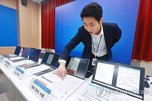 '주식 거래 빙자' 신종 피싱조직 검거 압수품(서울=연합뉴스) 진연수 기자 = 5일 서울 마포구 서울경찰청 광역수사단에서 남철안 서울경찰청 광역수사단 형사기동대 피싱범죄수사계 관계자가 '주식 거래 빙자' 신종 피싱조직 검거 관련 브리핑에 앞서 가짜 주식 서류, 가짜 사이트 서버파일 등을 나열하고 있다. 2025.8.5 jin90@yna.co.kr