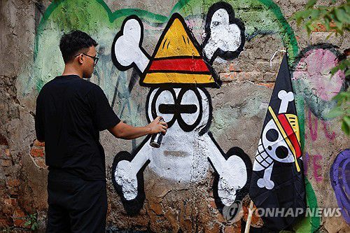 인도네시아의 '원피스' 해적 깃발 벽화지난 7일(현지시간) 서자바주에 사는 벽화예술가 케마스 무함마드 피르다우스(28)가 '원피스' 만화의 해적 깃발 그림을 벽에 그리는 모습. 2025.08.09 [로이터 연합뉴스 자료사진. 재판매 및 DB 금지]