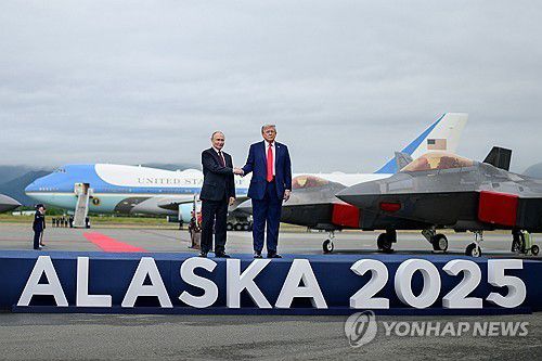 미 공군 F-22 전투기가 도열된 활주로 무대에서 악수하는 트럼프와 푸틴 [알래스카 UPI=연합뉴스. 재판매 및 DB 금지]