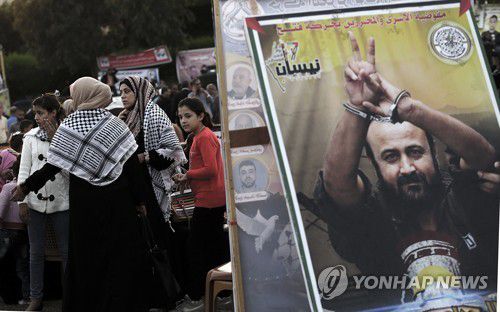 바르구티의 대형 포스터 옆에 서있는 팔레스타인인들[EPA=연합뉴스 자료사진]