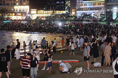광안리서 무더위 식히는 시민, 관광객들(부산=연합뉴스) 강선배 기자 = 찜통더위가 계속된 16일 밤 부산 수영구 광안리해수욕장에서 드론쇼를 관람한 시민과 관광객들이 더위를 식히고 있다. 2025.8.16 sbkang@yna.co.kr