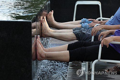 오늘도 무더위(서울=연합뉴스) 서대연 기자 = 서울 한낮 기온이 33도까지 오르며 더운 날씨를 보인 21일 서울 종로구 광화문광장에서 시민들이 흐르는 물이 발을 대고 있다. 2025.8.21 dwise@yna.co.kr