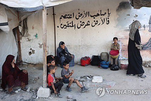 PALESTINIAN-ISRAEL-CONFLICT26일(현지시간) 가자시티의 자이툰 인근에서 팔레스타인 주민들이 피난 도중 길가에서 휴식을 취하고 있다. [AFP=연합뉴스]