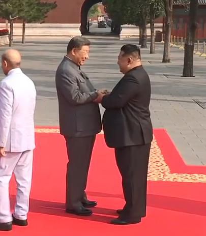 시진핑 중국 국가주석(왼쪽)과 김정은 북한 국무위원장이 두 손을 맞잡고 인사하는 장면[CCTV 캡처]