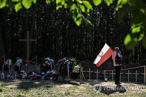 재매장 장례식에 폴란드 국기를 지참한 추모객 [로이터 연합뉴스 자료사진]